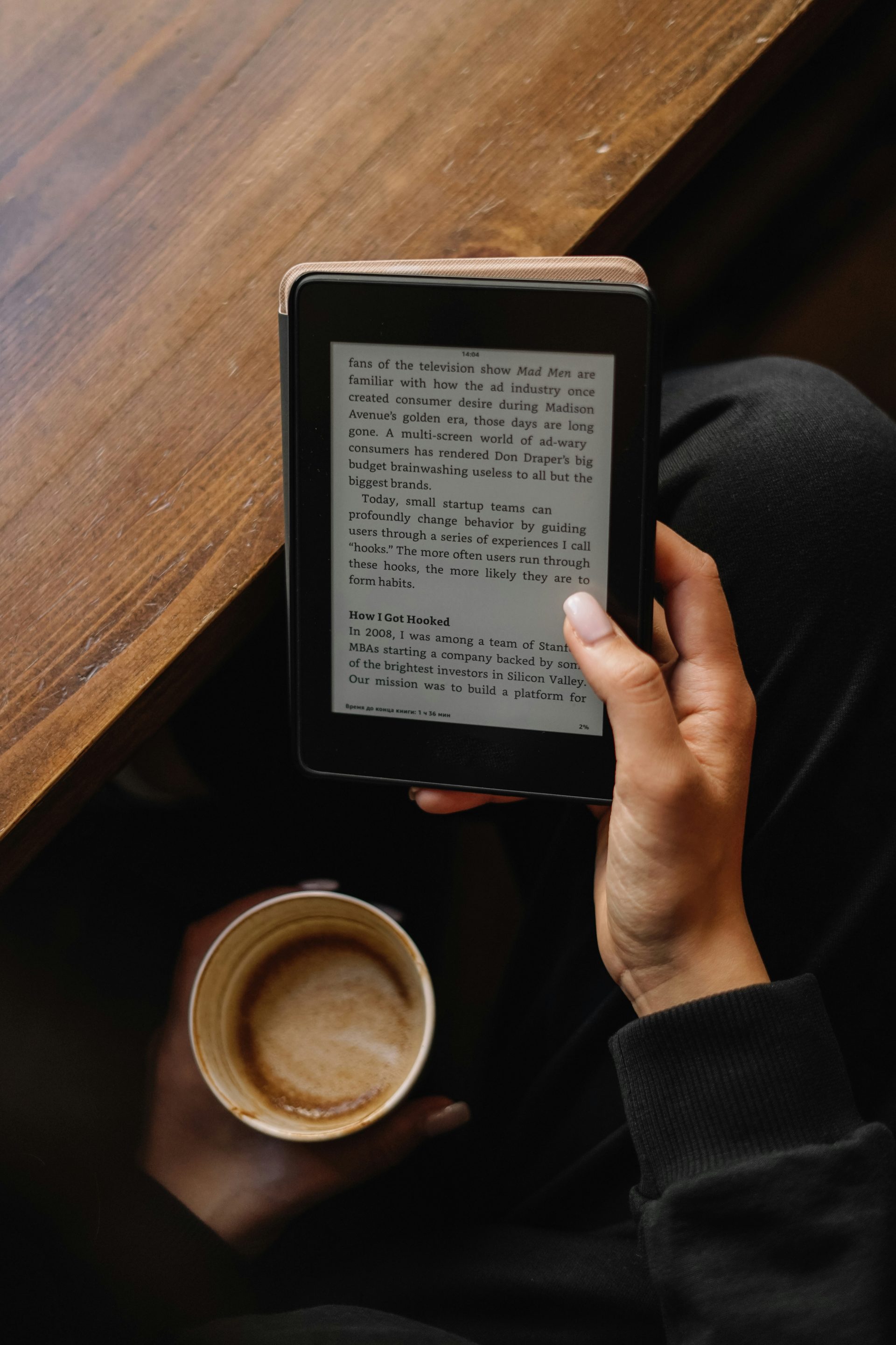 a person holding a tablet with a book on it